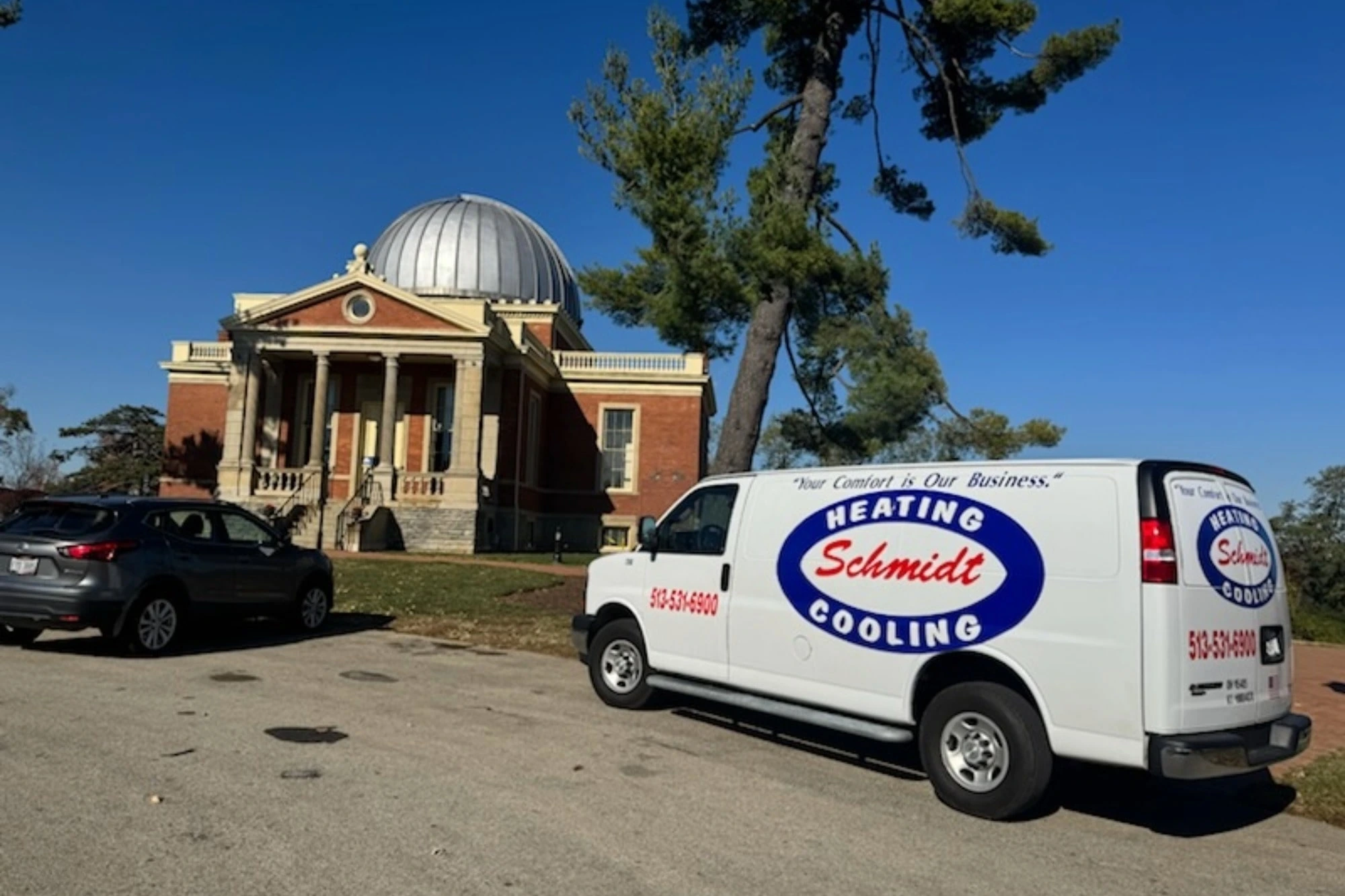 Schmidt Heating and Cooling service van parked near historic domed building on a clear day